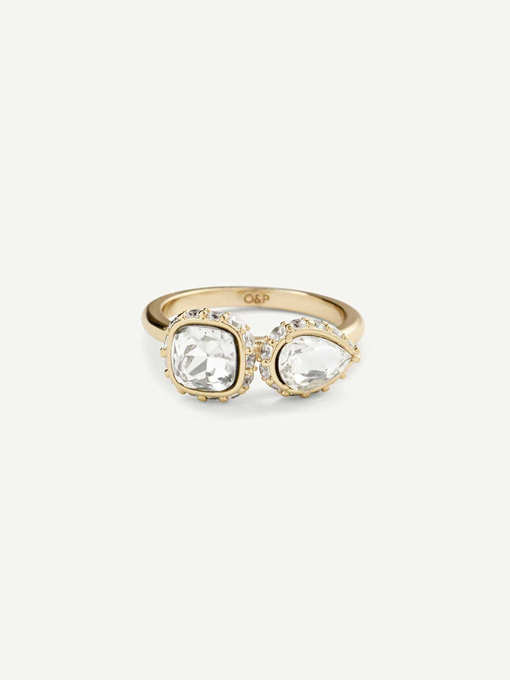 Gold ring with two clear gemstones on a white background